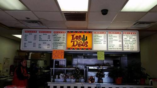 Menu board at a taco shop displaying Mexican and American food options, with a "Cash Only" sign.