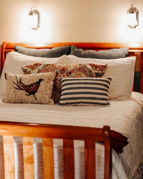 Cozy bed with decorative pillows, warm lighting, and a quilted cover in a softly lit room.