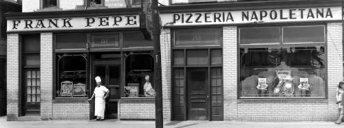 Historic black-and-white photo of Frank Pepe Pizzeria Napoletana, featuring a chef outside the restaurant.