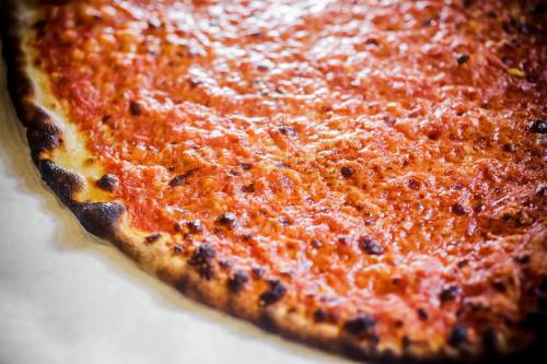 Close-up of a freshly baked pizza with a golden crust and a rich, tomato sauce topping.