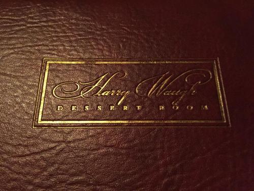 Close-up of a brown leather menu cover with gold lettering that reads "Harry Waugh Dessert Room."