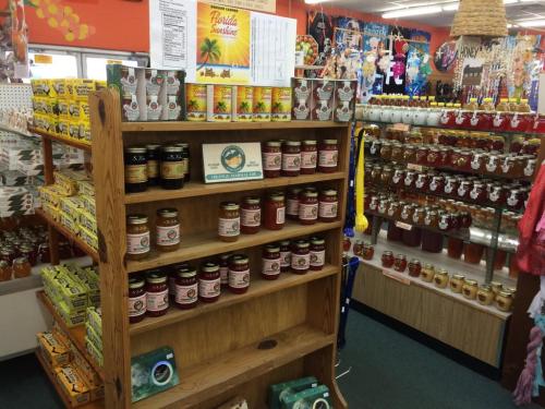 A colorful store display featuring shelves of jars, honey, and various local products in a vibrant setting.