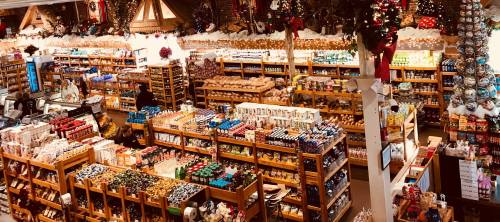 A festive store filled with shelves of colorful products, holiday decorations, and twinkling lights.
