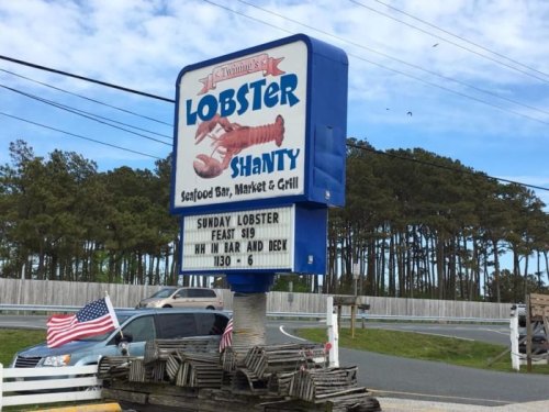 Sign for "Lobster Shanty" featuring a lobster graphic, promoting a Sunday lobster feast from 11:30 AM to 6 PM.