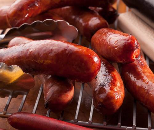 Grilled sausages glistening on a rack, showcasing a rich, smoky color and appetizing texture.