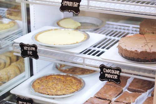 Display case filled with various desserts, including key lime pie, lemon bar, chocolate mousse, and pecan pie.