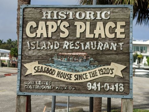 Sign for Cap's Place Island Restaurant, a historic seafood house since the 1920s, featuring a boat graphic.