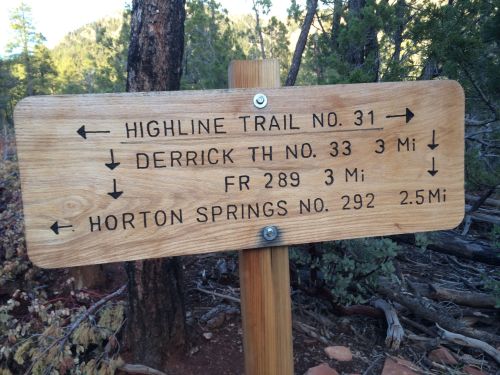 Wooden trail sign with directions and distances to Highline Trail, Derrick TH, FR 289, and Horton Springs.