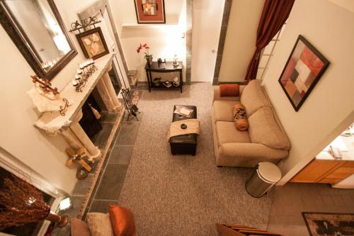 Cozy living room with a fireplace, beige sofa, decorative mirrors, and warm lighting, viewed from above.