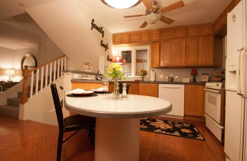 Cozy kitchen with wooden cabinets, a round table set for two, and a warm, inviting atmosphere.