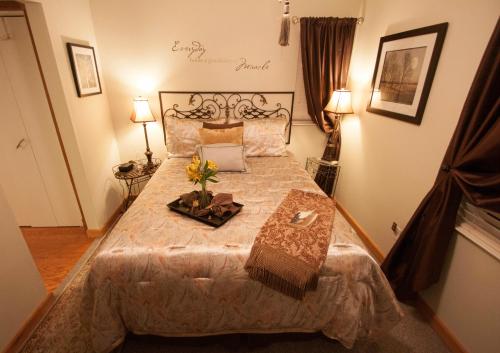 Cozy bedroom with a neatly made bed, decorative pillows, lamps, and wall art, creating a warm and inviting atmosphere.