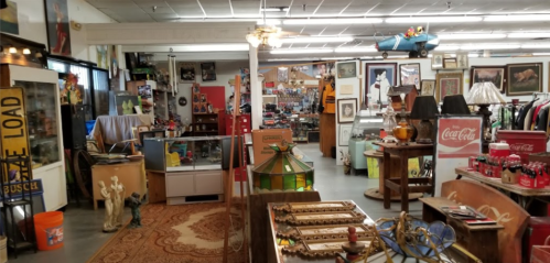 A vintage shop filled with antiques, artwork, and collectibles, featuring various displays and decor items.