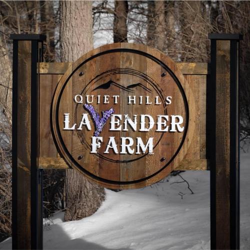 Sign for "Quiet Hills Lavender Farm" surrounded by trees and snow.
