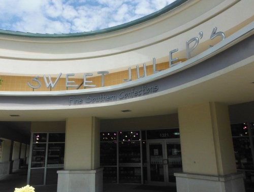 Sign for "Sweet Julep's Fine Southern Confections" on a storefront with a cloudy sky above.