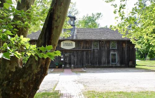 A rustic wooden building surrounded by trees, featuring a sign that reads "Lehman’s." Pathway leading to the entrance.