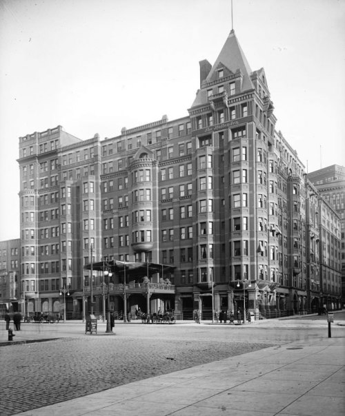 Historic building with ornate architecture, featuring a turret and large windows, set in an urban street scene.