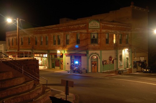 Historic brick building at night, featuring Hotel Connor and nearby shops, illuminated by streetlights.