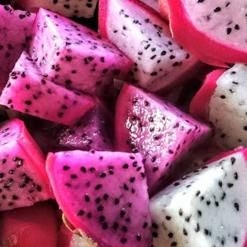 Close-up of vibrant pink and white dragon fruit cubes, showcasing their unique texture and black seeds.