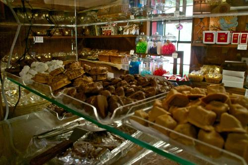 A display of assorted candies and chocolates in jars and trays, set in a cozy shop.