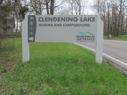 Sign for Clendenning Lake Marina and Campground, featuring directions and the Muskingum Watershed Conservancy District logo.