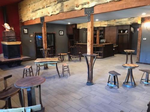 A cozy interior with wooden furniture, including small tables and chairs, and a bar area in a rustic setting.