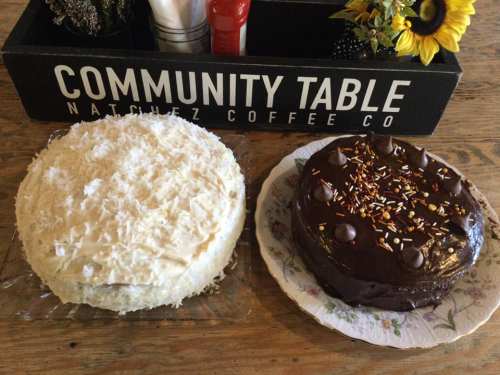 Two cakes on a table: one is a white coconut cake, and the other is a chocolate cake with sprinkles and chocolate chips.