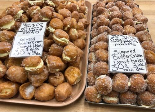 Two trays of donut holes: one with glazed buttercream and the other with sugared buttercream, each labeled with prices.