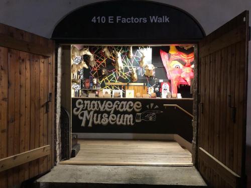 Entrance to the Graveface Museum, featuring eclectic decor and a vibrant, colorful backdrop.