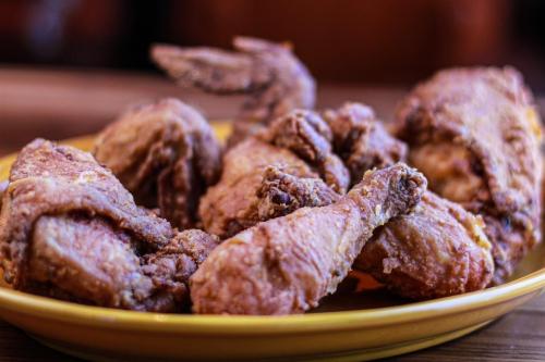 A close-up of crispy, golden-brown fried chicken pieces on a yellow plate.