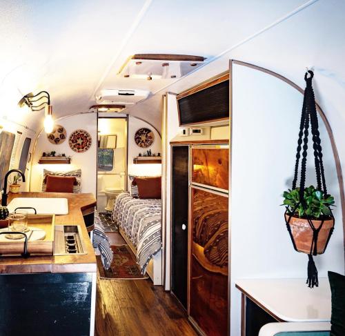 Interior of a stylish camper van featuring a kitchen, dining area, and cozy sleeping space with warm lighting.