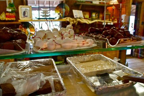 A display of assorted chocolates and confections, including chocolate-covered cherries and fudge, in a shop setting.