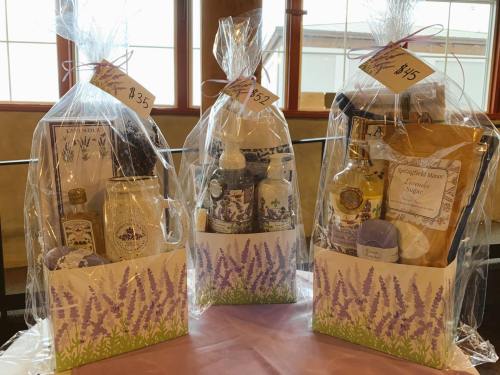 Three gift baskets wrapped in cellophane, featuring lavender-themed products and labeled with prices.