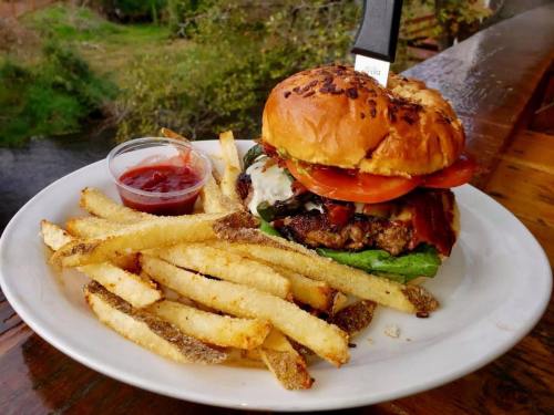 A juicy burger with lettuce, tomato, and bacon, served with crispy fries and a side of ketchup.