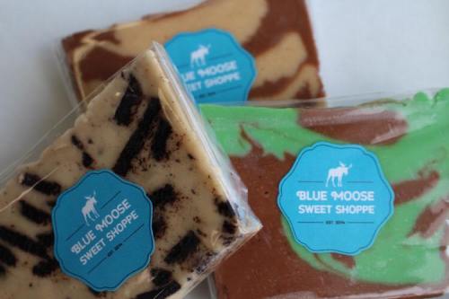 Three colorful fudge bars in clear packaging, featuring the "Blue Moose Sweet Shoppe" logo.