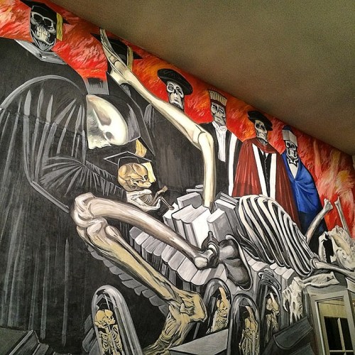 A vibrant mural depicting skeletons and figures in historical attire, showcasing themes of death and mortality.