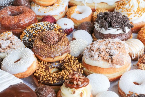 A colorful assortment of donuts with various toppings, including sprinkles, chocolate, and cream, arranged together.