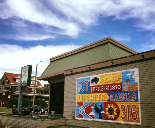 Colorful mural on a building in Wichita, Kansas, featuring local symbols and the text "Established 1870."