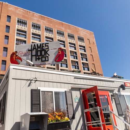 A building with a sign for James Hook & Co., featuring a lobster graphic, in an urban setting.