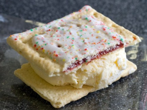 A dessert featuring two frosted pop tarts sandwiching a scoop of ice cream.
