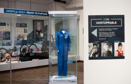 Exhibit featuring a blue astronaut suit and a sign reading "I AM UNSTOPPABLE" in a museum setting.