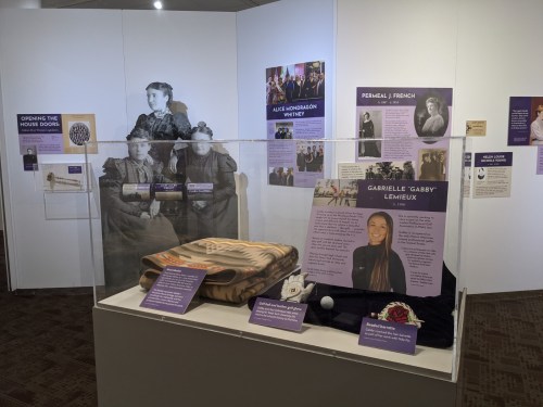 Exhibit showcasing historical figures and artifacts, including a blanket and information panels about notable individuals.