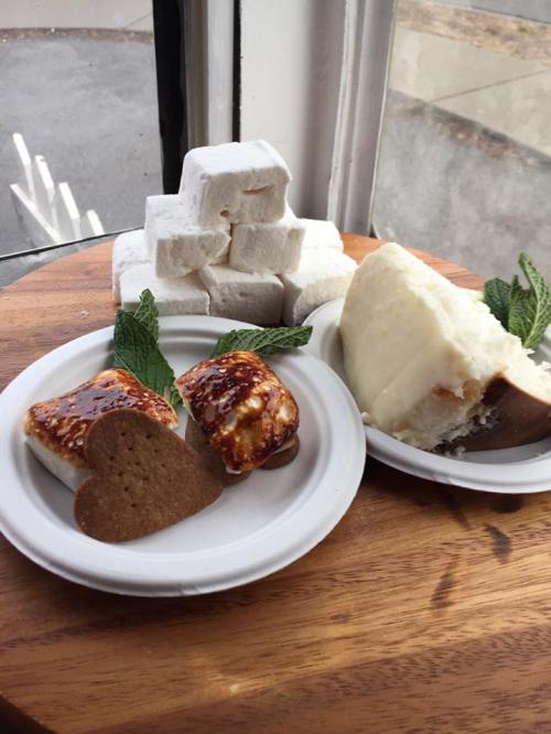 Two plates of desserts: one with marshmallows and gingerbread cookies, the other with a creamy cake and mint leaves.