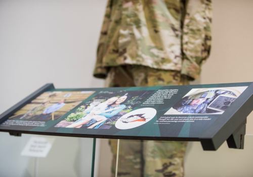 Exhibit display featuring a military uniform, photos, and text about service members and their families.