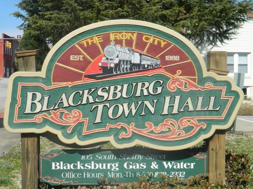 Sign for Blacksburg Town Hall, featuring a train graphic and details about the office location and hours.