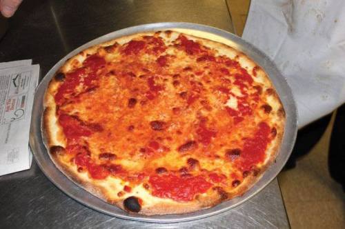 A freshly baked cheese pizza on a metal tray, with a golden crust and tomato sauce.