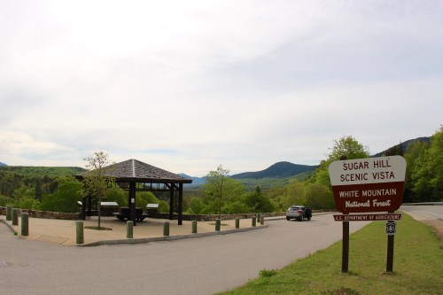 View of Sugar Hill Scenic Vista in White Mountain National Forest, featuring a gazebo and a sign at the roadside.