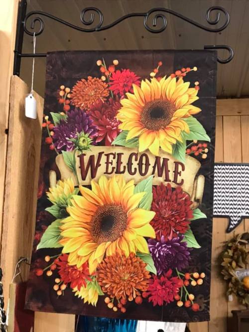 A decorative welcome banner featuring sunflowers and colorful flowers on a dark background.
