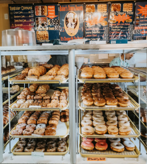 A display case filled with various types of donuts, including glazed, chocolate, and sprinkled options.