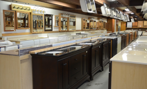 Showroom displaying various bathroom vanities, sinks, and mirrors arranged in rows.
