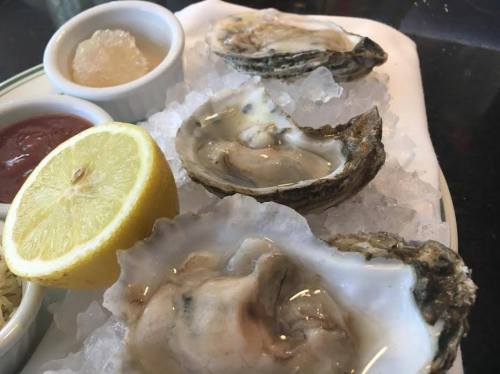 Fresh oysters on ice, served with lemon wedges and dipping sauces.